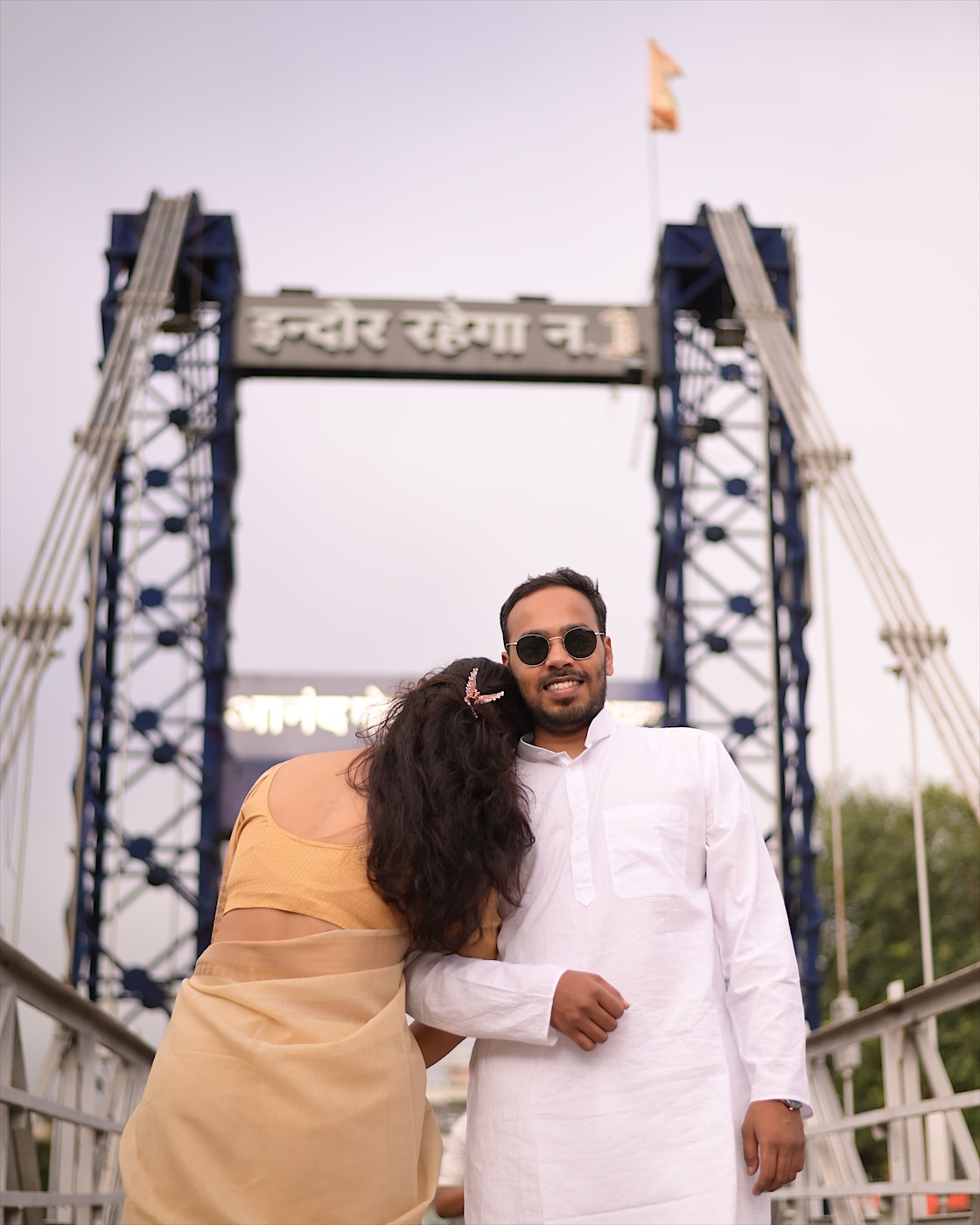 Astha leaning on Suyash on the bridge