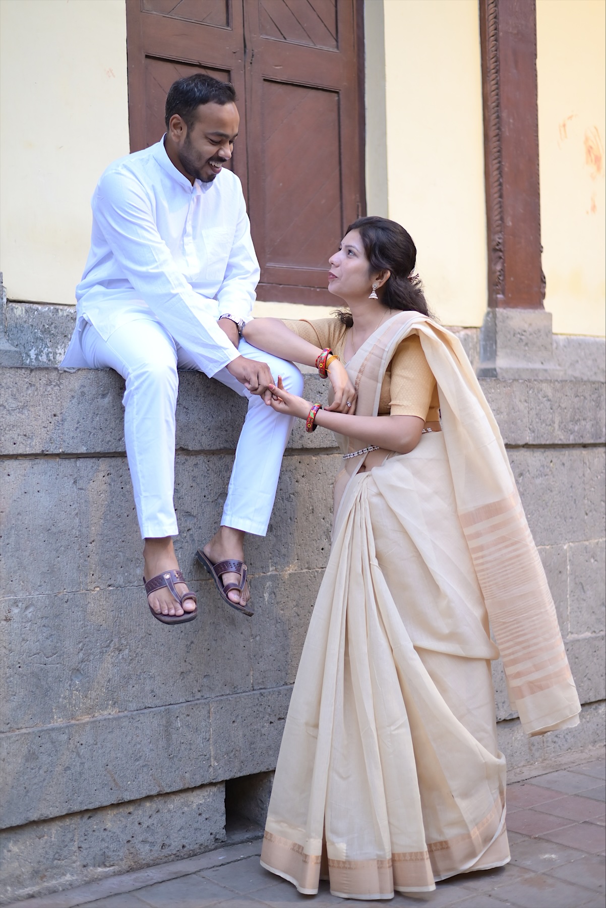 Suyash on the wall, holding Astha's hand